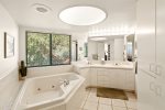 Unwind in the ensuite bathroom with a sunken tub, shower and double sinks